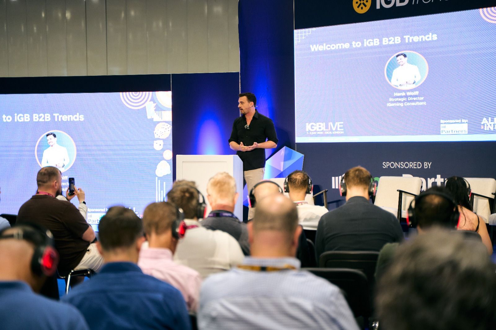 Henk Wolff on stage at iGB Live London opening the iGB B2B Trends track in front of a seated conference audience.